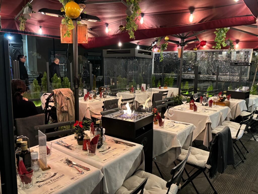 Sala esterna del ristorante, con piantine e stufe riscaldanti