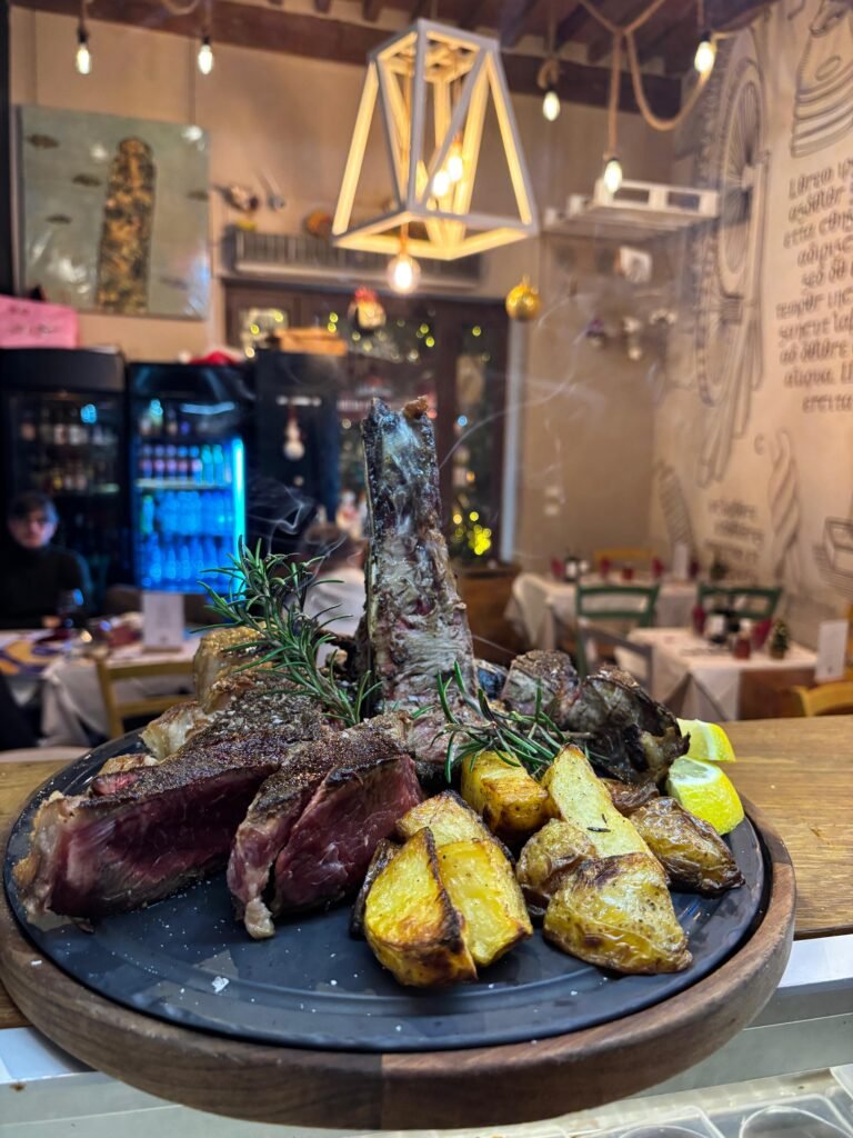bistecca appena cotta ancora fumante, con sfondo del ristorante. servita con patate e rosmarino