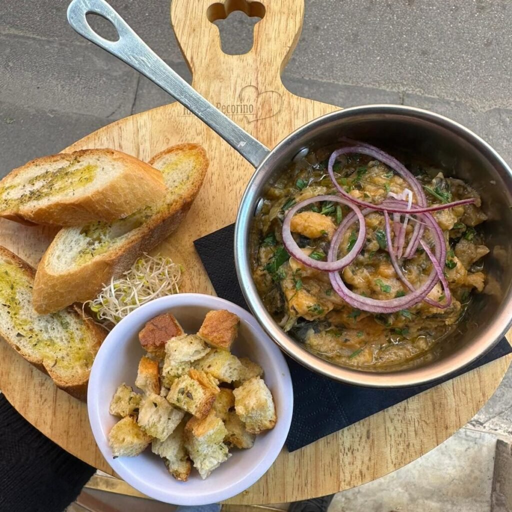 Ribollita, tipica zuppa toscana servita con crouton e fette ti pane tostato